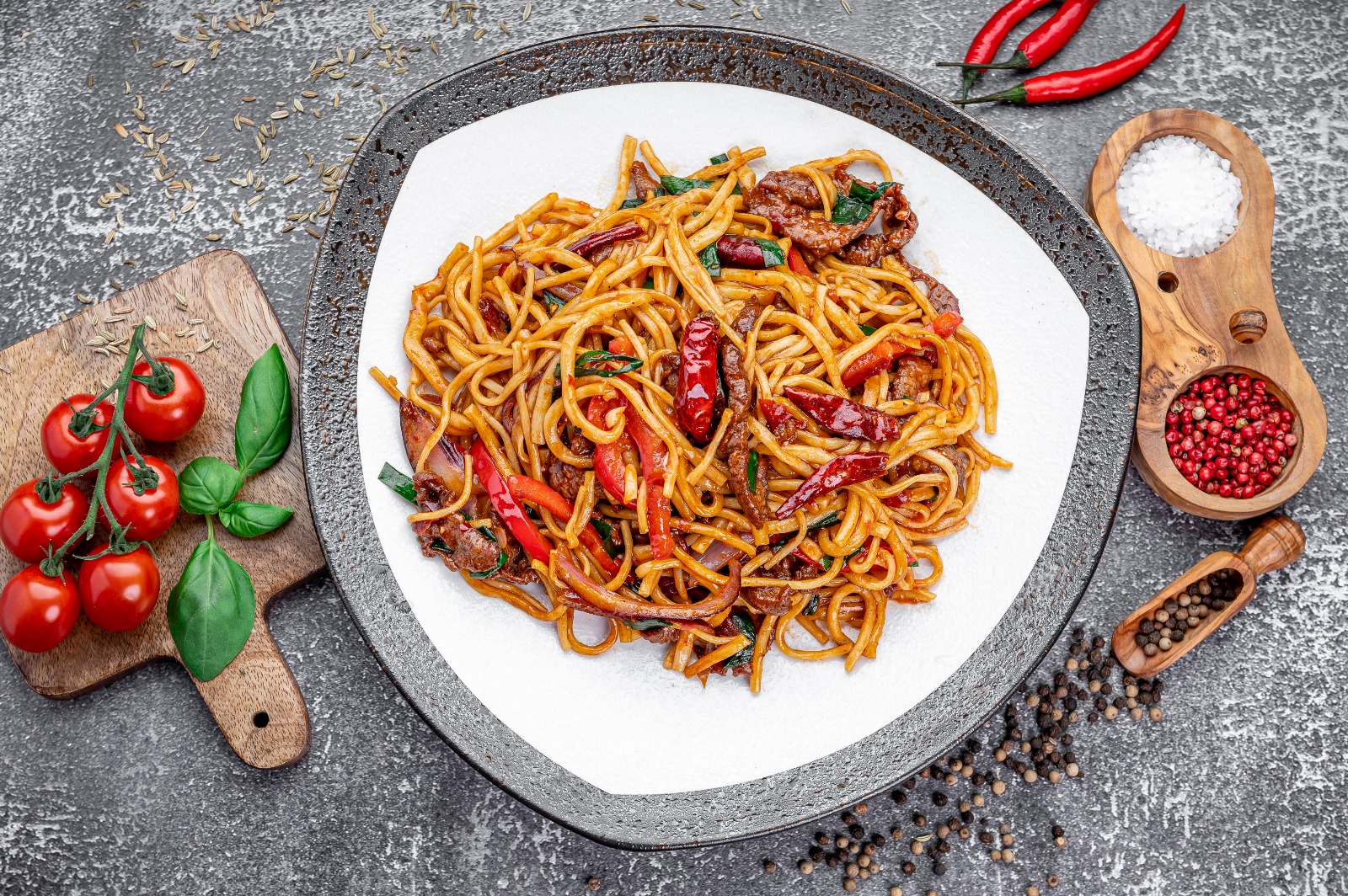 Noodles tossed in a wok over open flame