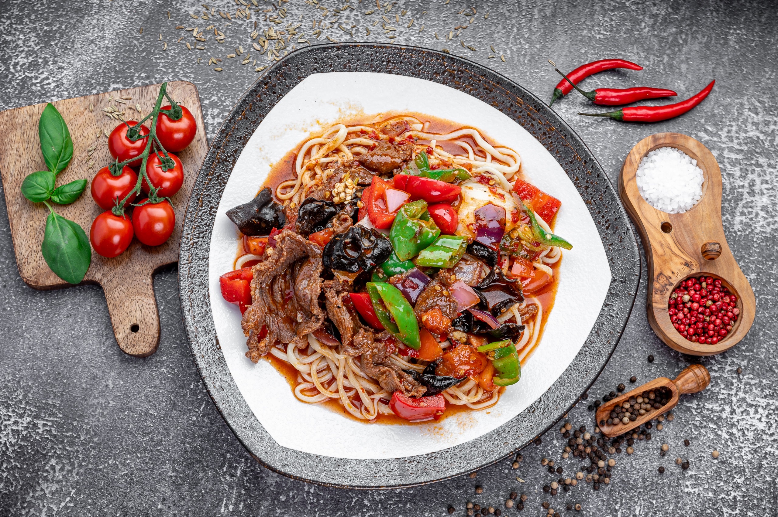 Hand-pulled laghman noodles under a wok topping